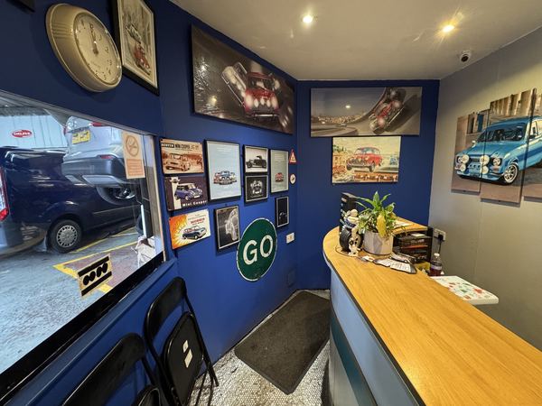 DJ Motors reception area with Mini Cooper memorabilia, classic car prints and welcoming counter